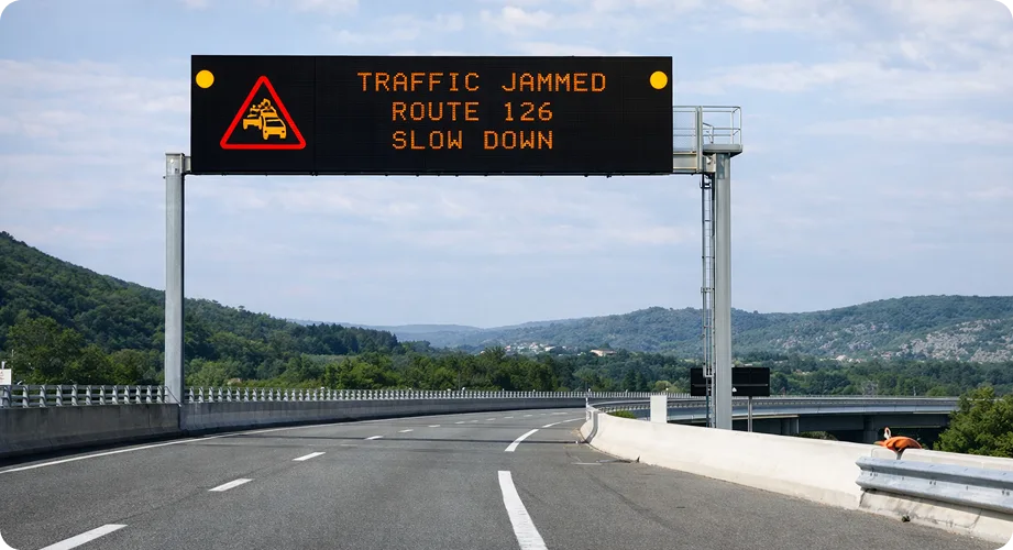 Ador fixed gantry variable message sign displaying TRAFFIC JAMMED ROUTE 126 SLOW DOWN above a highway