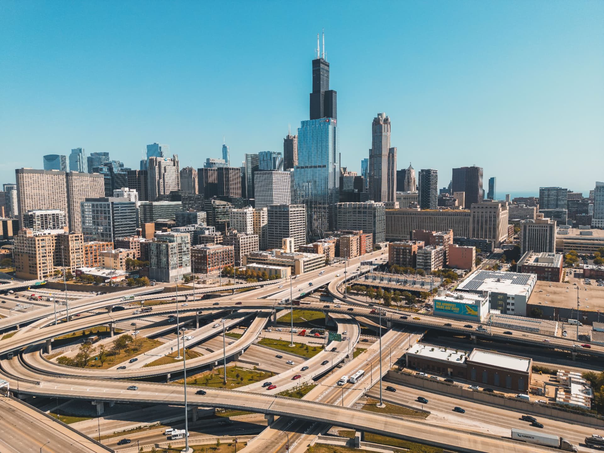 Elevated highway interchange feeding fast-moving traffic past a city skyline.
